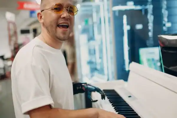 A Person Wearing Shades And Playing A Piano. The Person Has A Prosthetic Arm. | Evolve Prosthetics &Amp; Orthotics A Person Wearing Shades And Playing A Piano. The Person Has A Prosthetic Arm.