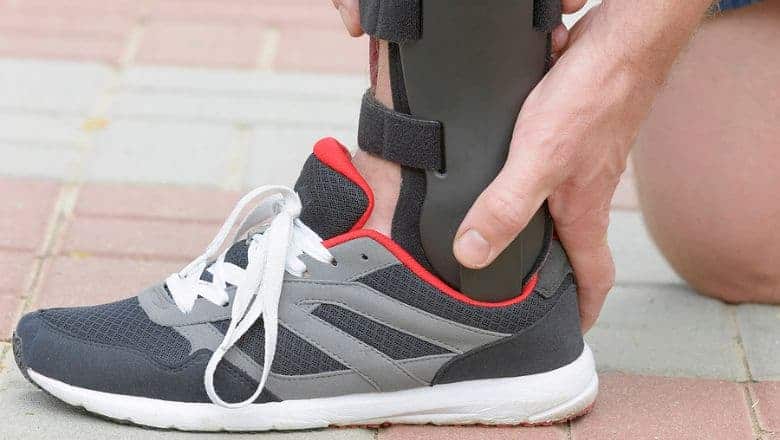 Foot With A Sports Brace In A Black, White, And Red Tennis Shoe