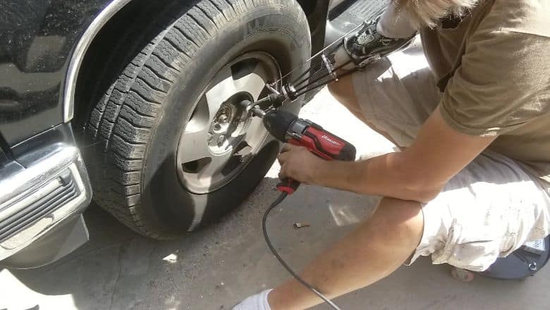 Person With Prosthetic Arm Removes Bolts On A Vehicle Tire | Evolve Prosthetics &Amp; Orthotics Person With Prosthetic Arm Removes Bolts On A Vehicle Tire