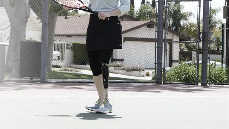 A Person With An Artificial Leg Holding A Tennis Racket.